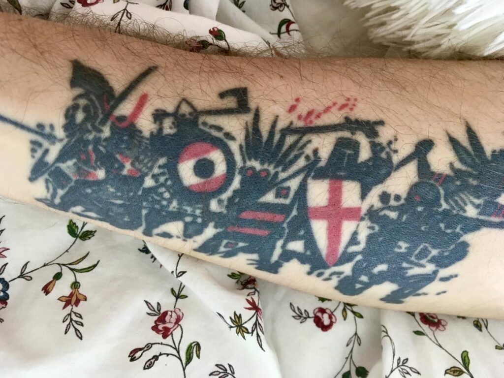 Kriger tatovering på indersiden af underarm placeret i blomstret sengetøj.
