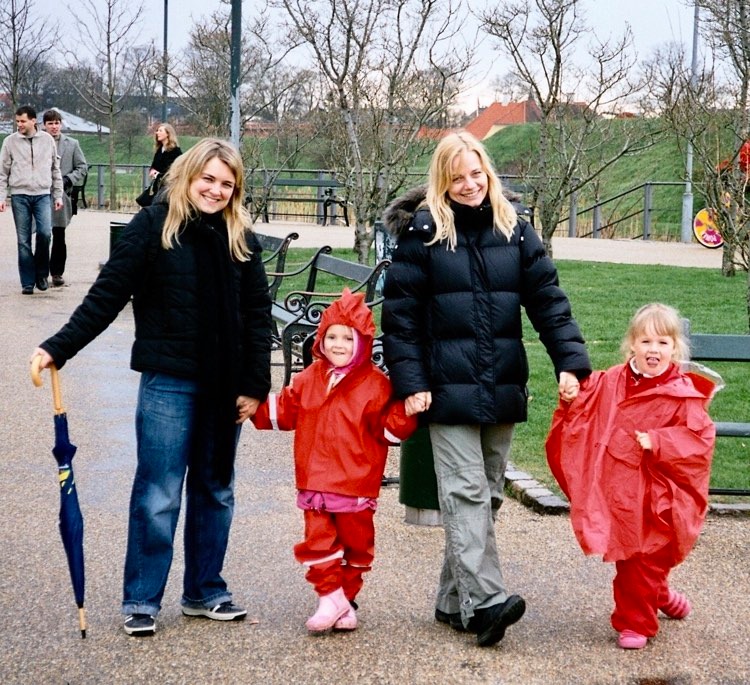 To unge kvinder med deres to døtre i rødt regntøj