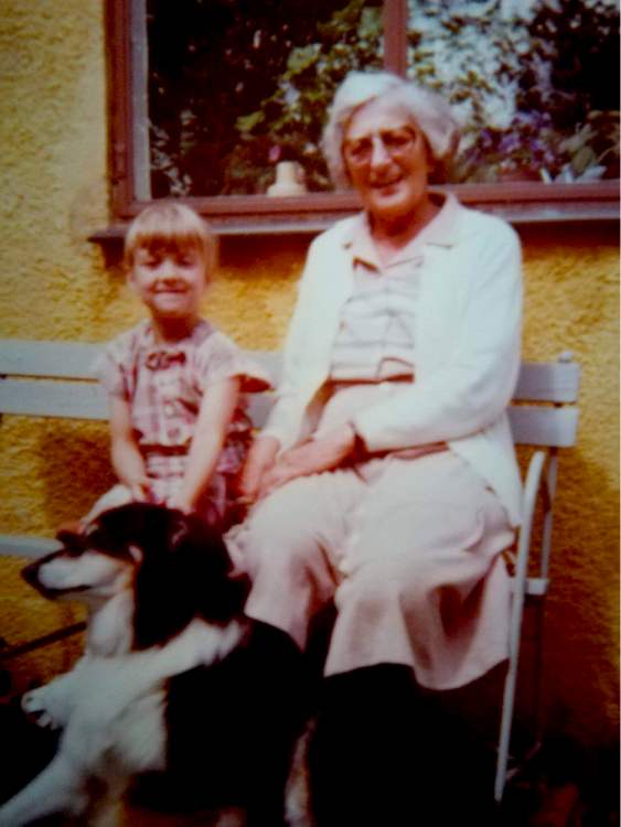 En lille pige, en hund og en gammel dame på en bænk