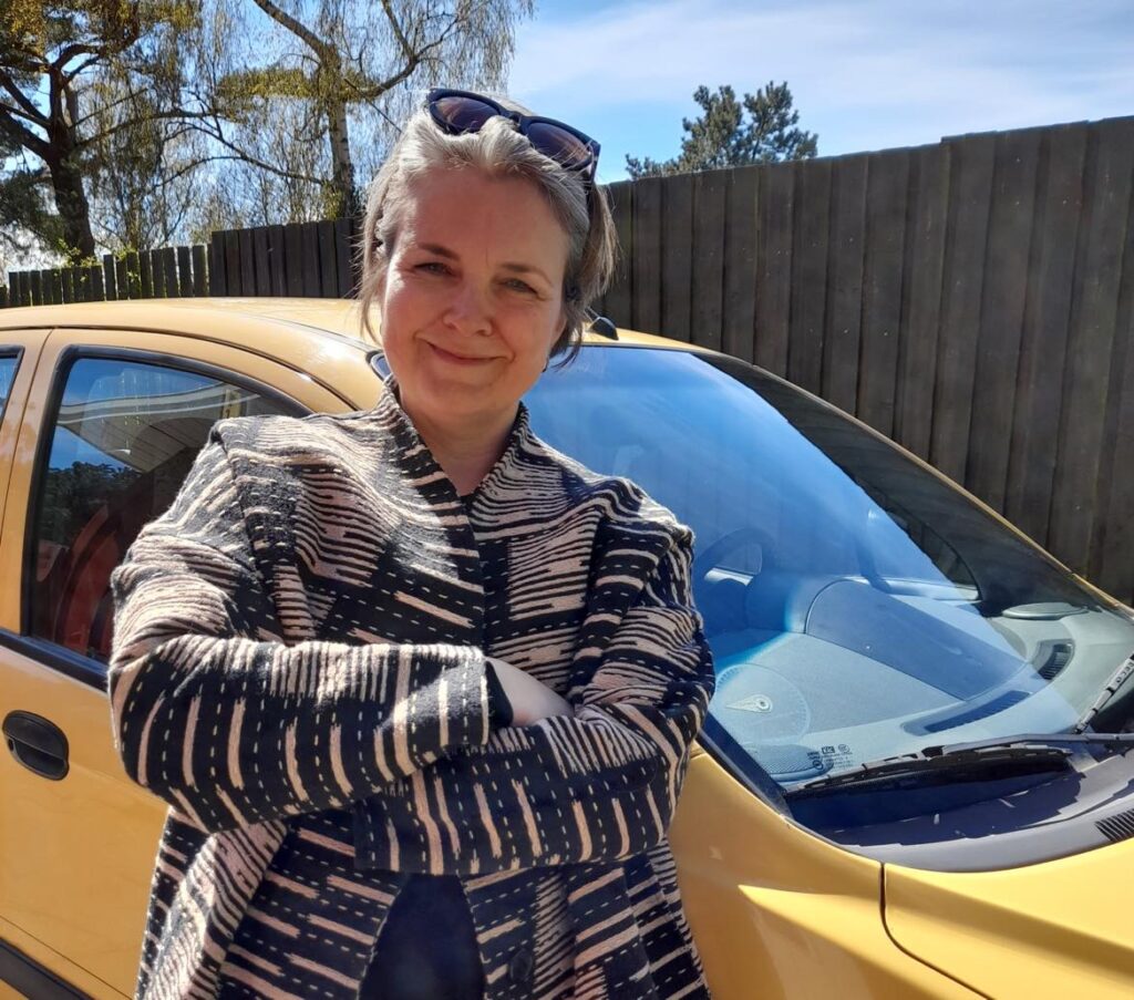 Eva Boland Kock foran sin gule bil