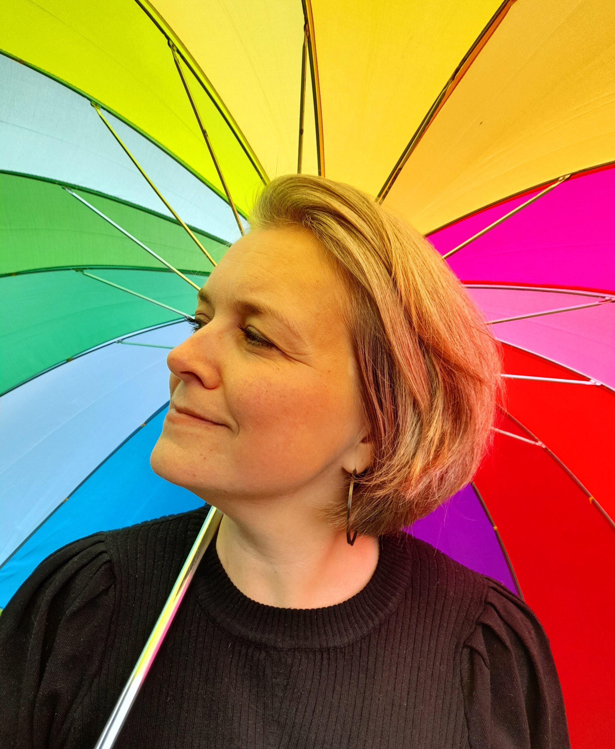 Eva i profil med regnbueparaply