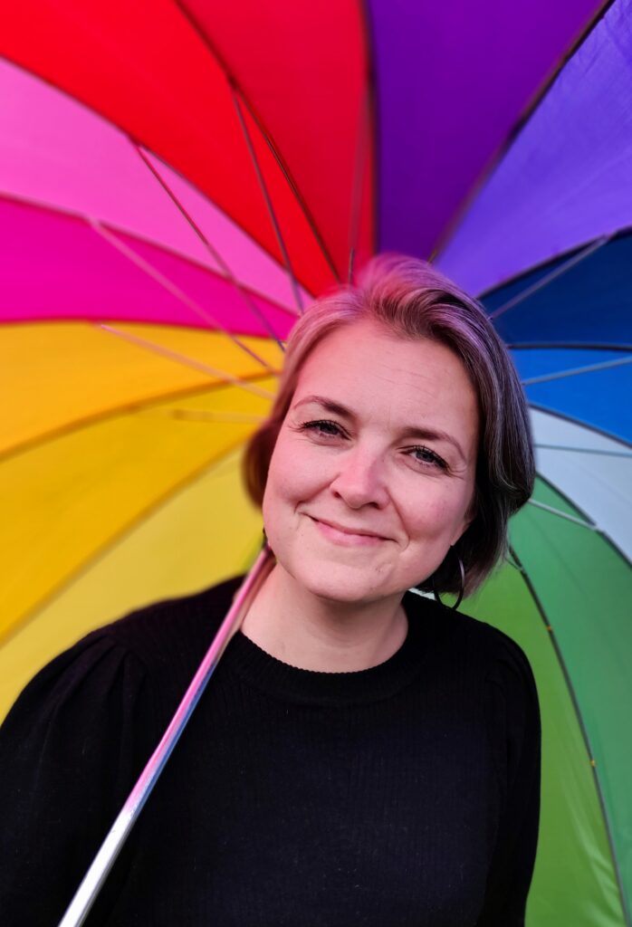 Eva smiler foran regnbueparaply
